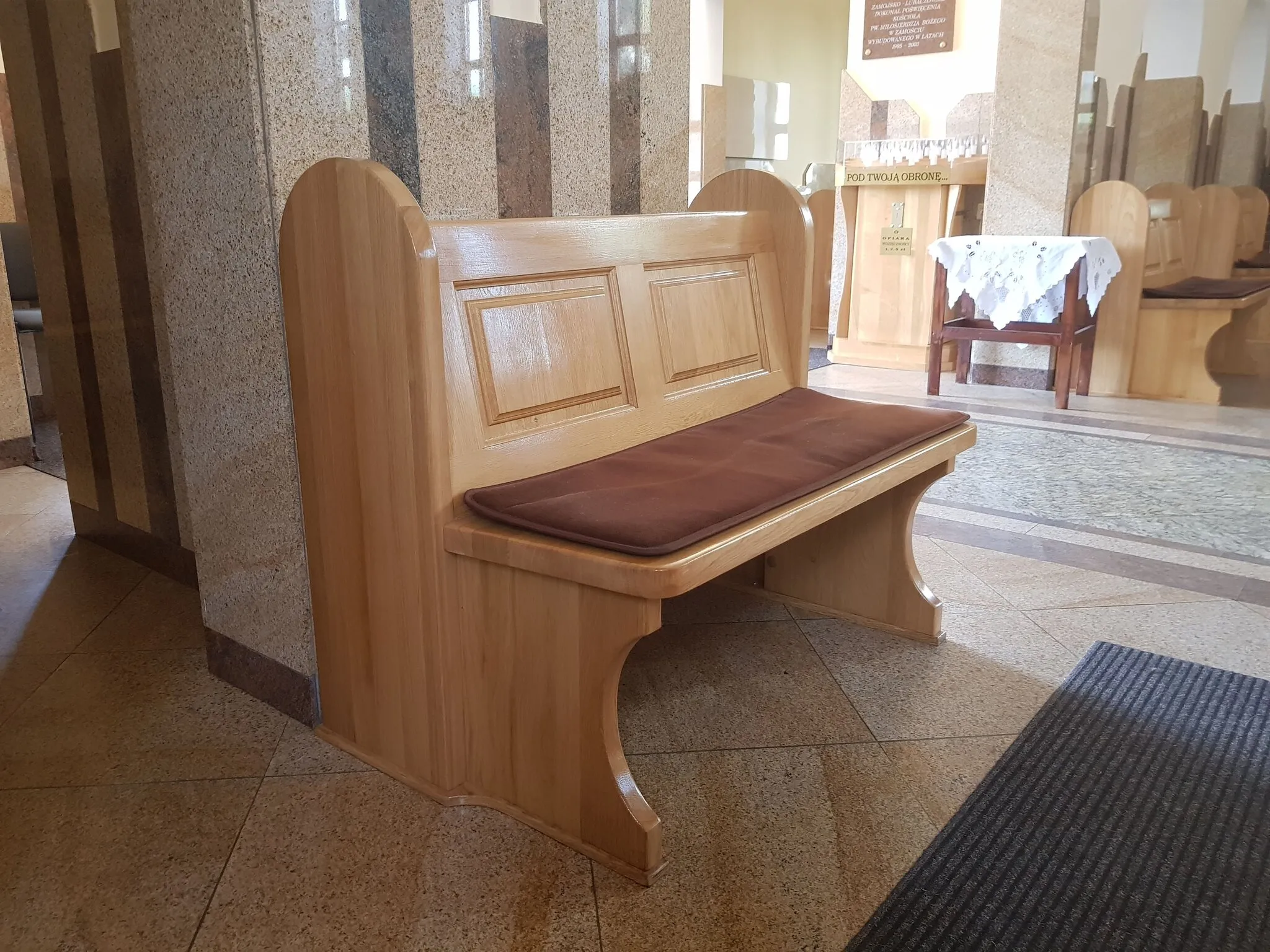 Konfesjonał widziany z boku, z ażurową kratą nad klęcznikiem