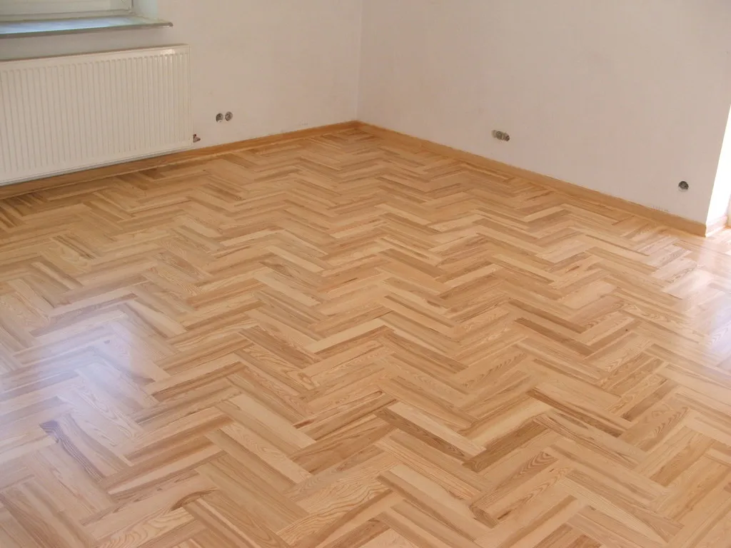 Podłoga ułożona w jodełkę francuską w jasnym pomieszczeniu